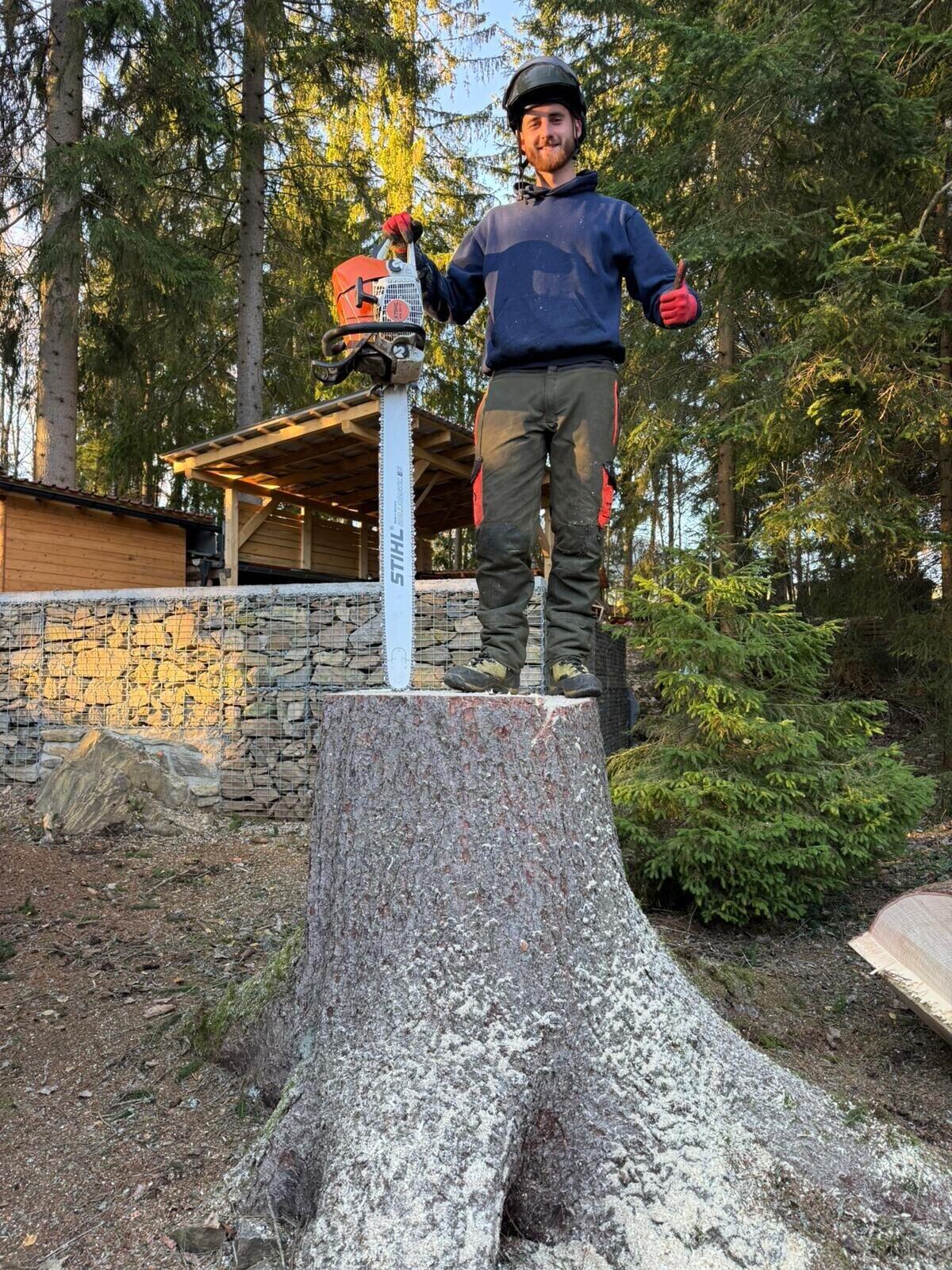 Filip Čarek s motorovou pilou po dokončeném kácení